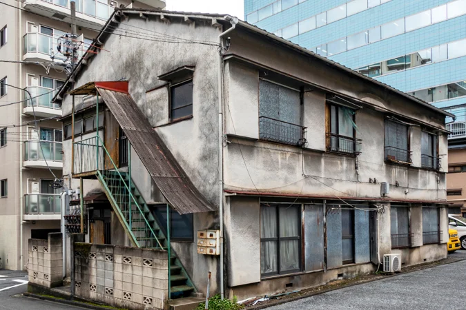 経年した二階建て木造アパートの外壁と共用通路
