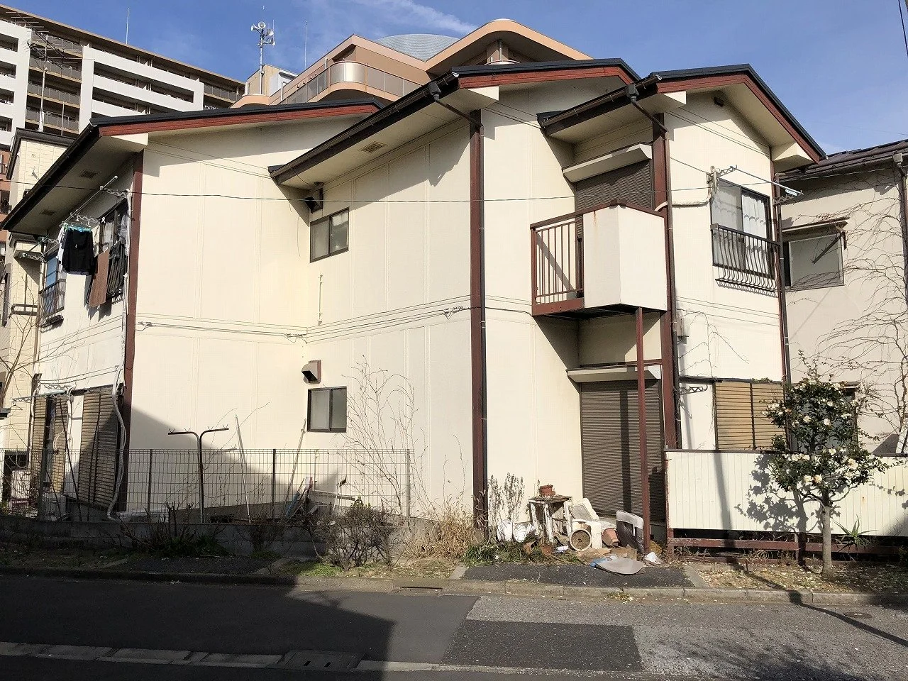 老朽化した二棟の住宅が並ぶ敷地と、片付け前の庭まわり